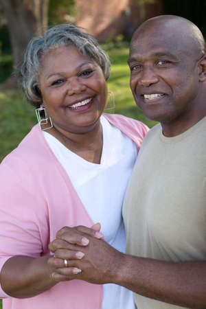 Mature African American couple laughing and hugging.の写真素材