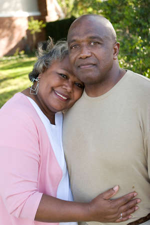 Mature African American couple laughing and hugging.の写真素材