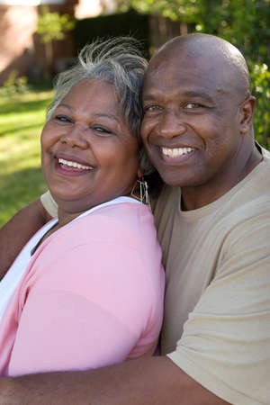 Mature African American couple laughing and hugging.の写真素材