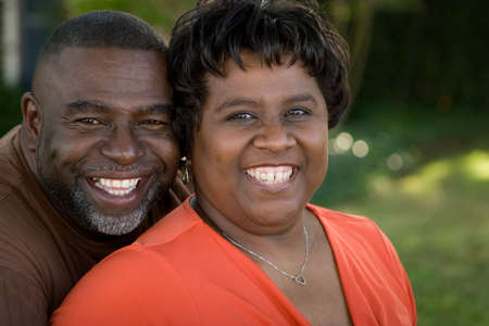 Mature African American couple laughing and hugging.の写真素材