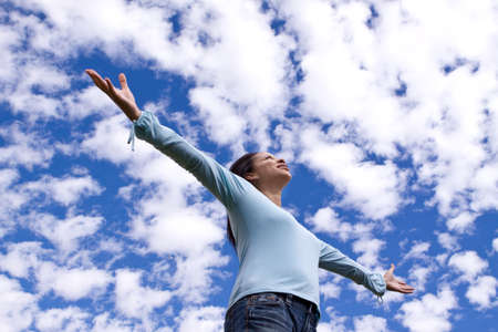 Happy woman standing outside with open arms.の写真素材