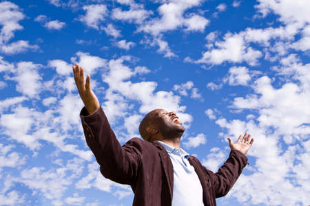 African American man standing outside with open arms.