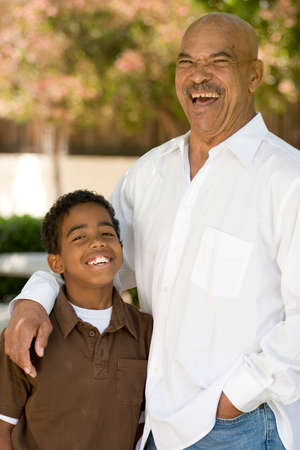 Happy African American grandfather and grandson laughing.