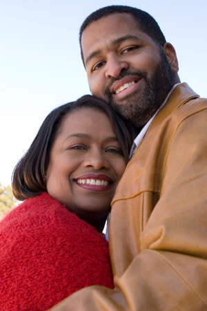 Mature African American couple laughing and hugging.の写真素材