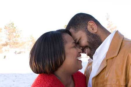 Mature African American couple laughing and hugging.