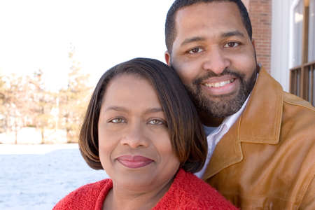 Mature African American couple laughing and hugging.の写真素材