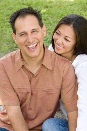 Portrait of an Asian couple laughing and hugging.の写真素材