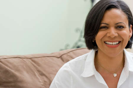 Smiling mature woman sitting on her sofa.の写真素材
