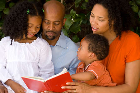 Loving African American parents reading with their kids.の写真素材