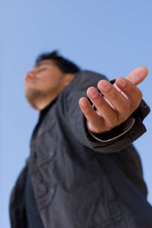 Hispanic man with open arm in prayer.