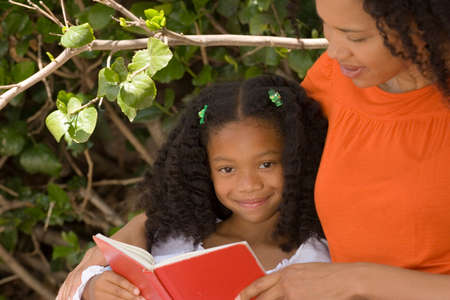 African American mother and her daugher reading.