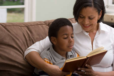 Mother and son reading on the sofa.