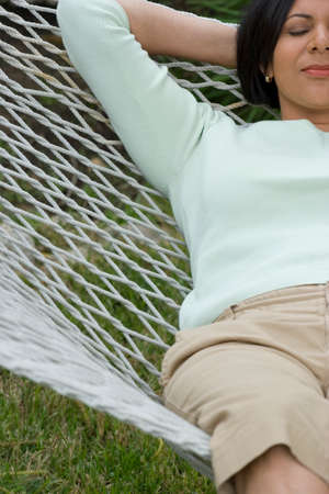 Mature African American woman relaxing in a hammock.の写真素材