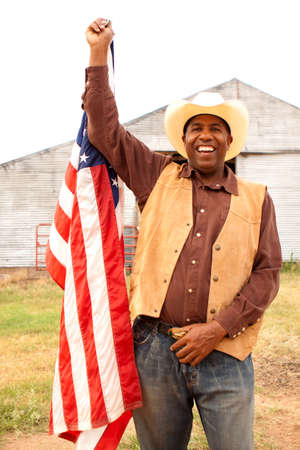 African American cowboy holding an American flag.の写真素材