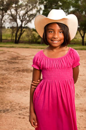 Hispanic little girl wearing a hat with an American flag.