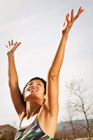 Heathly Asian woman exicited with hands in the air.の写真素材