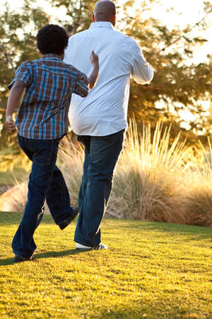 African American father and son playing outside.の写真素材