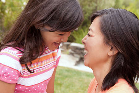 Loving Asian mother and daughter smiling.の写真素材