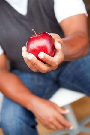 Mature man holding an apple.の写真素材