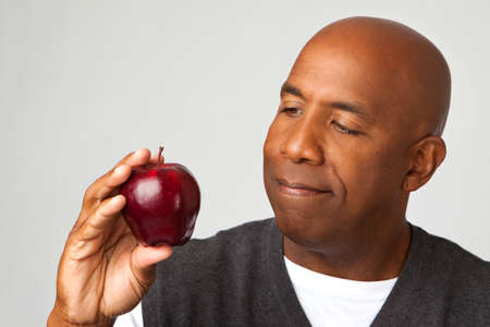 Mature man holding an apple.の写真素材
