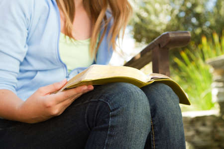 Young teen girl outside reading in the backyard.の写真素材