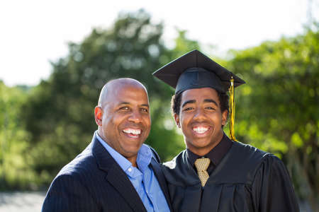 Father hugging his son at his graduation.の写真素材