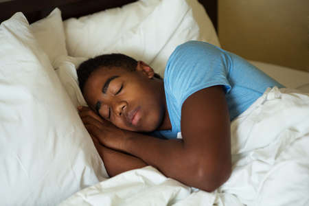 African American teenage boy sleeping.の写真素材