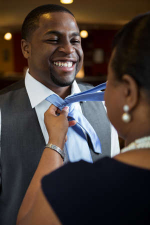 Mother helping her son tie his tie.の写真素材