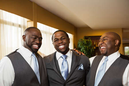 Groom and groomsmen smiling at a wedding.の写真素材
