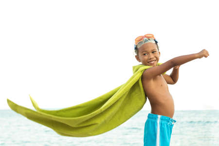 Young boy playing superhero on the beach.の写真素材