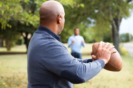 African American father and son playing fooball.の写真素材