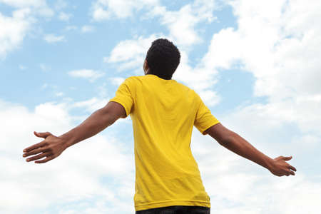 African American young teen boy with open hands to the sky.の写真素材