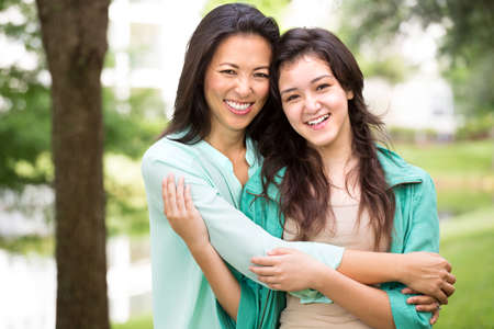 Asian mother laughing and huging her child.の写真素材