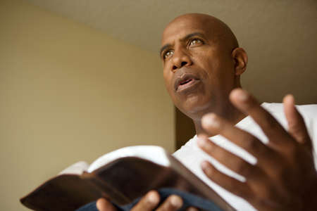 Portrait of an African American reading in deep thought.