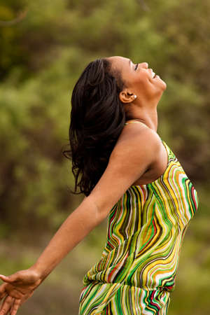 Happy woman sitting in a field smiling.