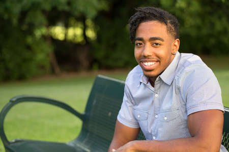 Young handsome African American man smiling outside.