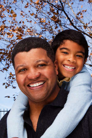 Biracial father and son laughing and smiling outside.の写真素材