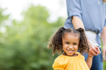 Mother and daugher laughing and playing at the park.の写真素材