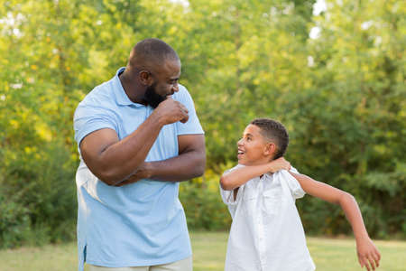 Father and his son laughing and playing at the park.の写真素材