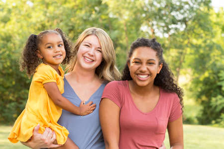 Happy mother and her two daughers laughing and smiling.の写真素材