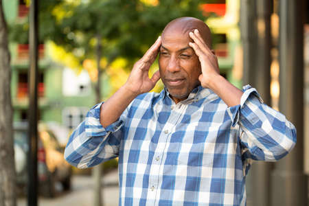 African American man ho.lding his head in painの写真素材