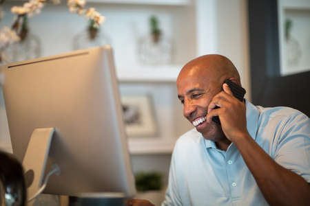 Mature African American man working from his home office.の写真素材