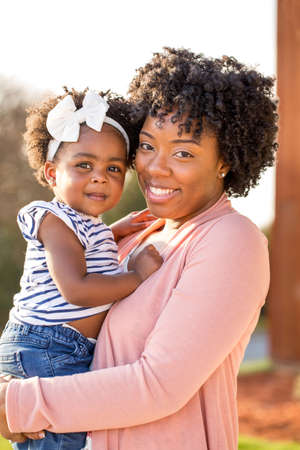 African American mother laughing and holding her daughter.の写真素材