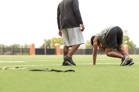 American Football coach training a young athlete.の写真素材