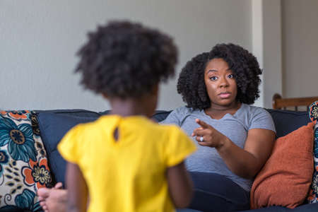 African American mother disciplining parenting her young child.の写真素材