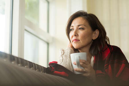 Portrait of a mature Asian woman in deep thought.の写真素材