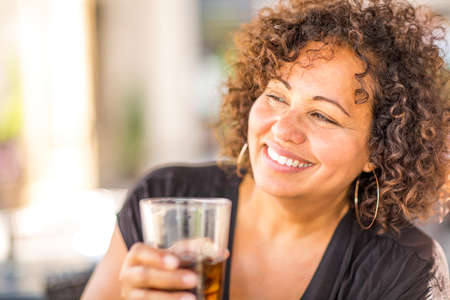 Portrait of a woman at a restaurant having a drink.の写真素材