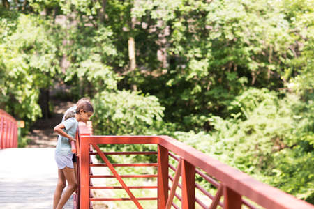 Portrait of a little girl standing on a bridge.の写真素材