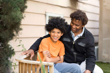 African American father hugging his son and smiling.の写真素材