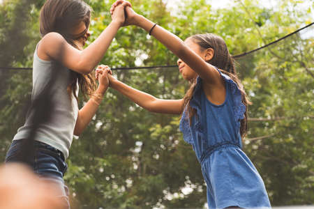 Little girls jumping and playing on a trampoline.の写真素材